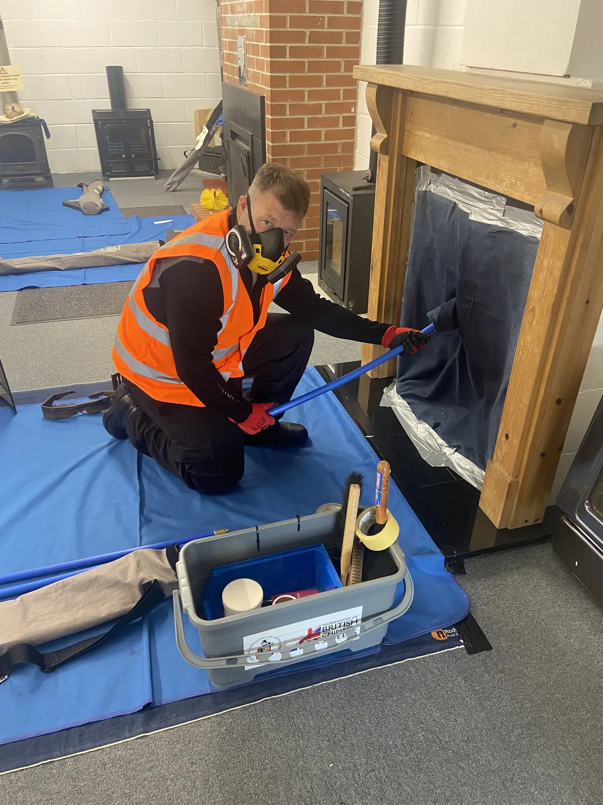 Dan sweeping a chimney with full dust sheets, floor protection and respiratory kit